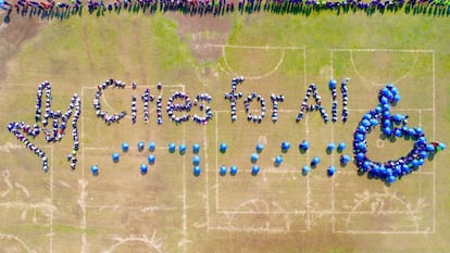 Vista aerea de la frase Cities for All, el signo internacional de accesibilidad y el gesto de amor en el lenguaje de señas americano