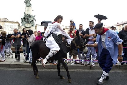 Varios blusas animan a una neska y su burro este viernes en Vitoria