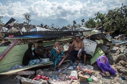 Unos supervivientes, se cobijan en las ruinas de una casa, en Palu.