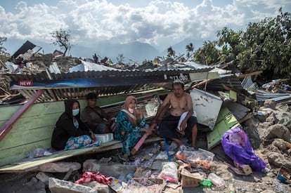 Unos supervivientes, se cobijan en las ruinas de una casa, en Palu.