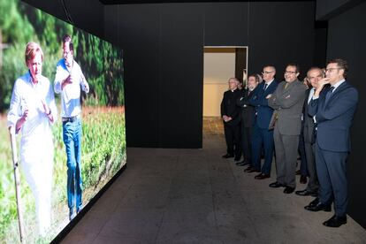 Alberto N&uacute;&ntilde;ez Feij&oacute;o, a la derecha, junto a Antonio Ca&ntilde;o y varios cargos del grupo Prisa, el delegado del Gobierno en Galicia y el arzobispo observan una foto de Merkel y Rajoy en el Camino de Santiago.