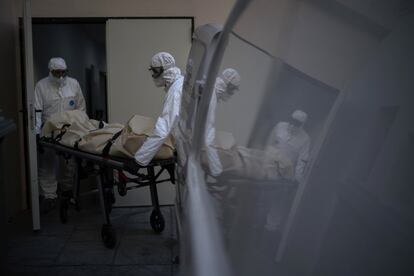 Two workers remove the body of a coronavirus victim from a seniors residence in Barcelona.