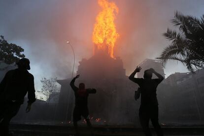 Un manifestante pasa frente a una barricada, en los alrededores de la Plaza Italia de Santiago (Chile), rebautizada popularmente como Plaza Dignidad, durante el primer aniversario de las protestas que sacudieron todo el país y que tuvieron su epicentro en la capital chilena.