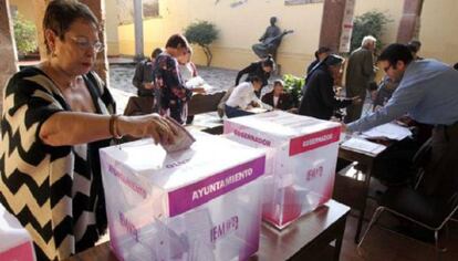 Una ciudadana deposita su voto en una mesa electoral.