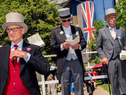 Un grupo de apostadores, atildados, de semblante serio y tocados con sombreros de copa, estudia y observa a los caballos en las carreras de Ascot.