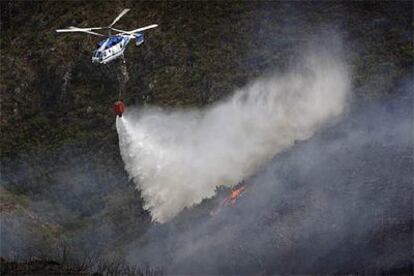 Un helicóptero descarga agua sobre el incendio de la Serra de l&#39;Almirant.