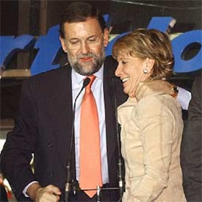 Mariano Rajoy abraza a Esperanza Aguirre, anoche, en el balcón de la sede <i>popular</i> de la calle Génova.
