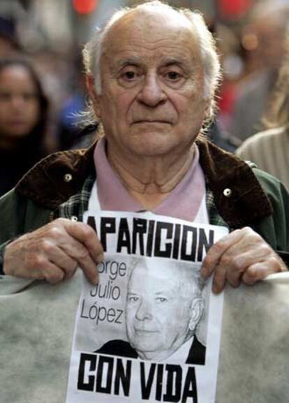 Un hombre lleva un cartel con la cara de Julio López durante una manifestación en Buenos Aires