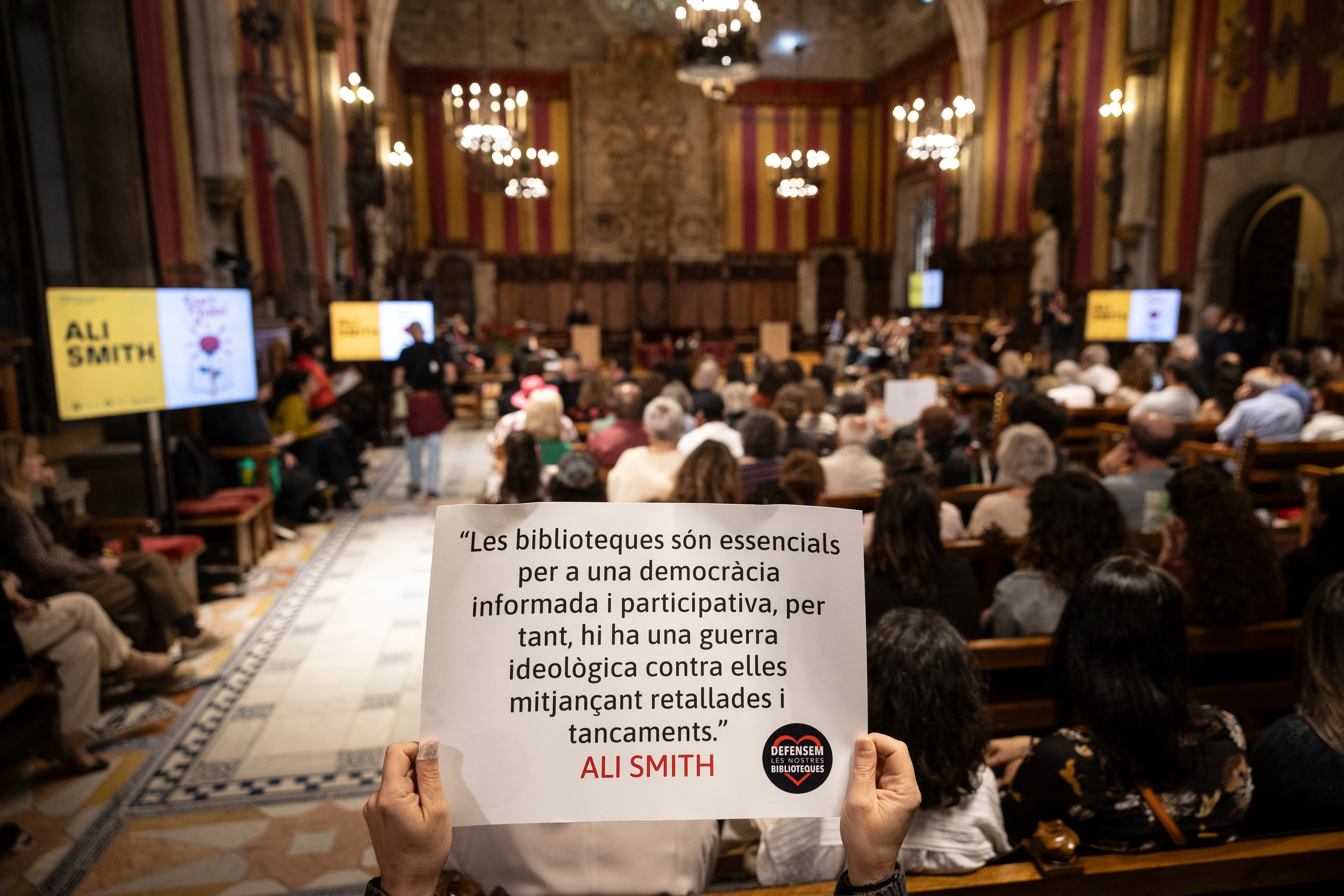 Un cartel en defensa de las bibliotecas públicas durante el pregón de Ali Smith en el Saló de Cent.