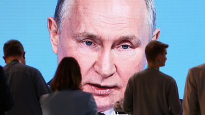 Asistentes a la reunión siguen por una pantalla el discurso de Putin, el jueves en San Petersburgo.