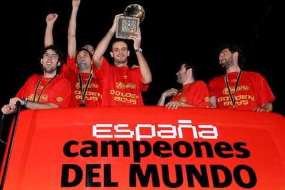 Los jugadores de la selección española de baloncesto, Berni Rodríguez, Felipe Reyes, el capitán Carlos Jiménez (con la copa), Carlos Cabezas y Jorge Garbajosa, saludan desde el autobús. Los jugadores se desplazaron por la ciudad en un un vehículo descubierto desde la sede de la Federación Española de Baloncesto hasta la Plaza de Castilla.