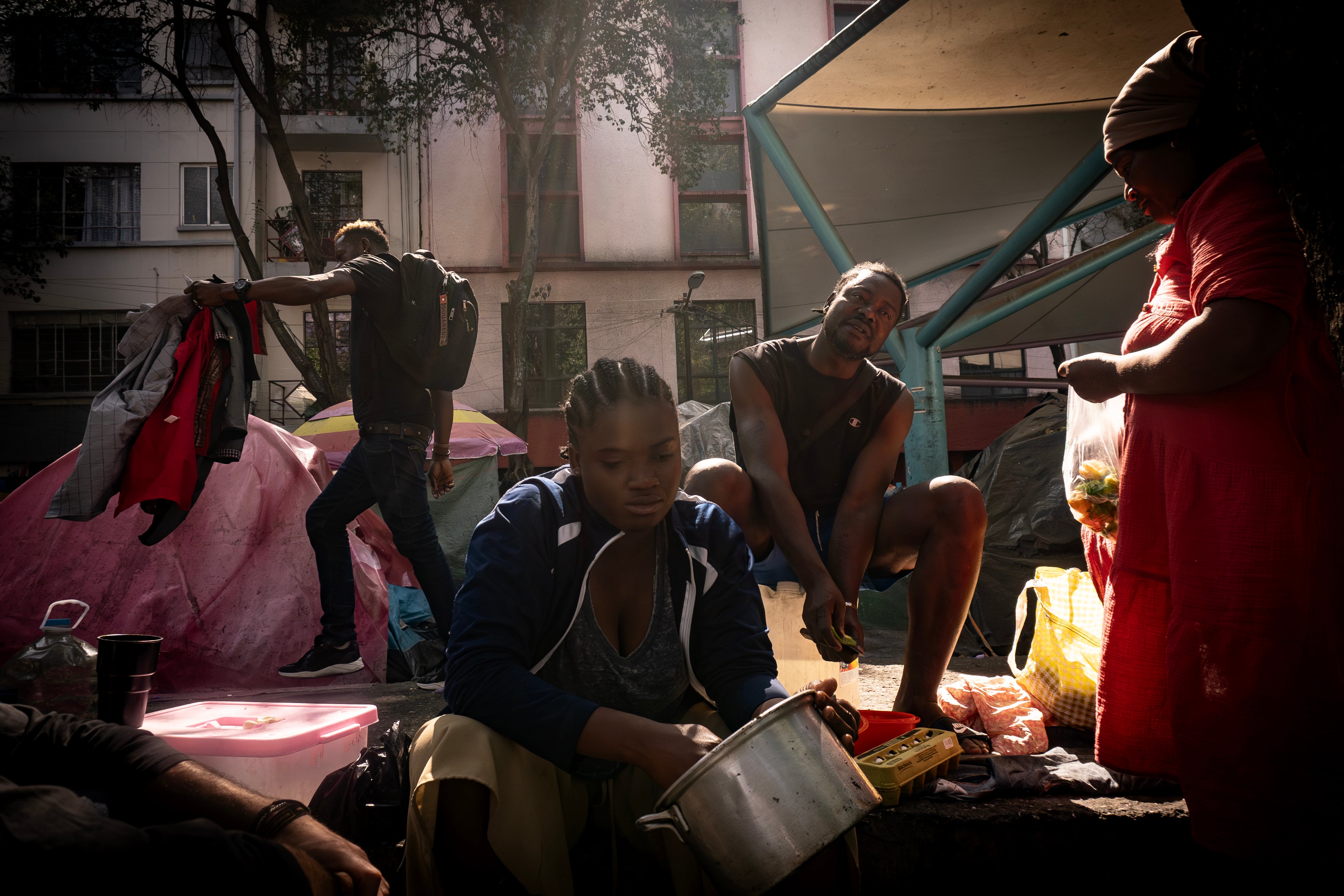 Migrantes haitianos cocinan y ordenan su campamento en la Plaza Giordano Bruno, en marzo de 2024. 