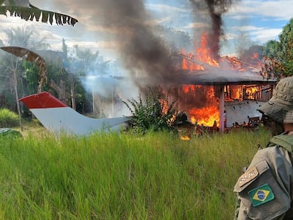 Un agente del Instituto Brasileño de Medio Ambiente (Ibama) observa la quema de una avioneta de mineros furtivos durante una operación en la tierra indígena yanomami, en febrero de 2023.