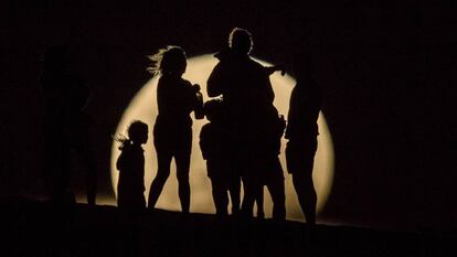 La gente mira la superluna elevándose en las dunas de arena en Lancelin (Australia).