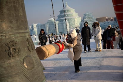 La llamada "campana del siglo", símbolo de la ciudad de Harbin, tocada por un visitante al Festival de Hielo y Nieve.