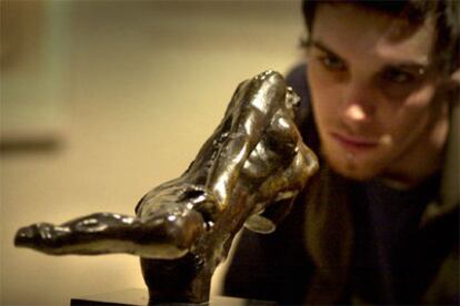 Un visitante mira una de las esculturas de Rodin incluidas en la exposición.