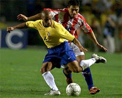 Acuña persigue a Roberto Carlos en el partido disputado en Porto Alegre entre Brasil y Paraguay.