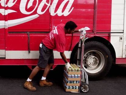 Un trabajador distribuye productos de Coca Cola.