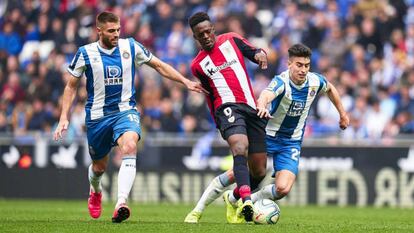 Williams da un pase entre David López y Marc Roca durante el Espanyol-Athletic.