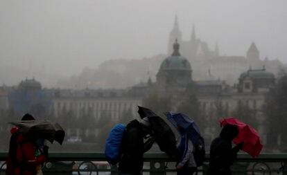 Un grupo de personas se protege de la lluvia y el viento con sus paraguas en Praga (República Checa) el 29 de octubre. El Instituto Hidrometeorológico Checo dijo que había registrado la ráfaga de viento más rápida en Snezka, la montaña más alta de la República Checa, con una velocidad máxima de 180 kilómetros por hora.