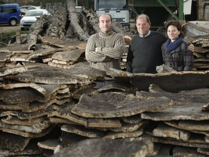 Le&oacute;n Miravet, entre sus hijos Adolfo y Herminia, junto a las pilas de planchas de corcho, en su f&aacute;brica Espad&aacute;n Corks, de Soneja.