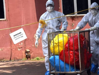 Personal médico con trajes protectores traslada objetos en bolsas del pabellón de infecciosos del Centro Médico Ernakulam en Kochi, Kerala (India), donde ha aparecido un brote del virus Nipah.