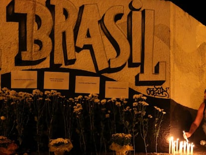 Mulher acende vela em tributo a vítimas do ataque em Suzano.