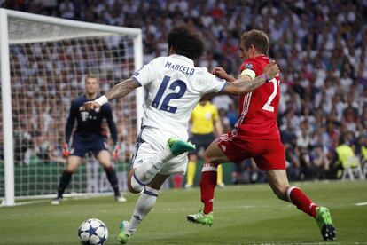El defensa brasileño del Real Madrid Marcelo Vieira (i) centra el balón junto a Philipp Lahm, del Bayern Múnich.