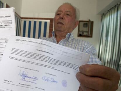 Pedro Ramos muestra el documento firmado para depositar sus ahorros. 