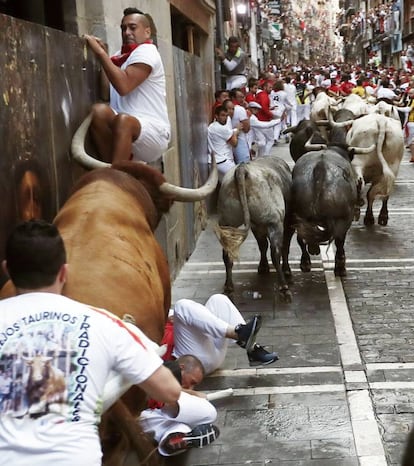 Corredores en la curva de la calle Mercaderes durante el último encierro de San Fermín.
