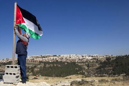 Un activista iza la bandera palestina en un campamento en Cisjordania, el 20 de enero.