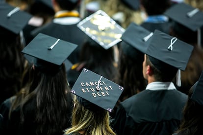 The cap of a University of Iowa graduates candidate is decorated with writing reading "Cancel student debt" during a commencement ceremony on May 14, 2022, at Carver-Hawkeye Arena in Iowa City, Iowa.