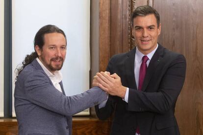 Iglesias y Sánchez se saludan tras firmar su acuerdo de investidura. 