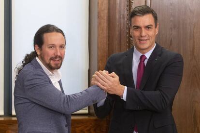 Iglesias y Sánchez se saludan tras firmar su acuerdo de investidura.