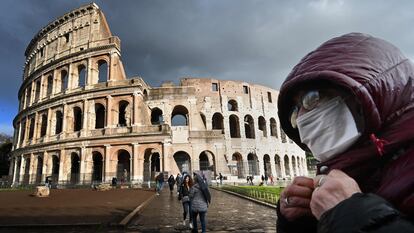 Um homem com máscara diante do Coliseu, em Roma.