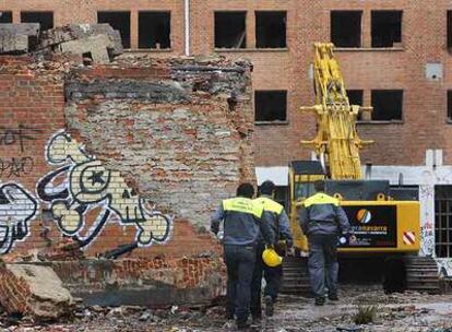 Varios operarios se dirigen al interior de la cárcel de Carabanchel.