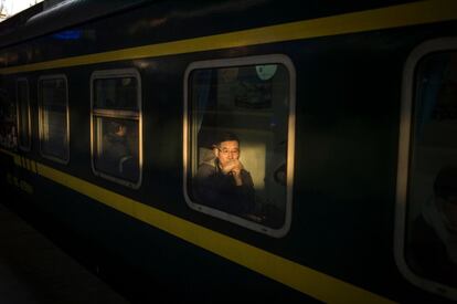 Algunos pasajeros esperan la salida del tren de vuelta a sus ciudades para celebrar el Año Nuevo Lunar, en la estación de tren de Pekín (China).