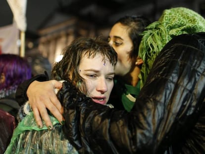 Manifestantes pró-aborto se abraçam sob a chuva em Buenos Aires.