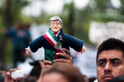 Un manifestante con un muñeco de López Obrador.