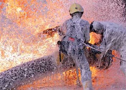 Bomberos iraquíes intentan sofocar un incendio en un oleoducto en las afueras de Bagdad.
/ REUTERS