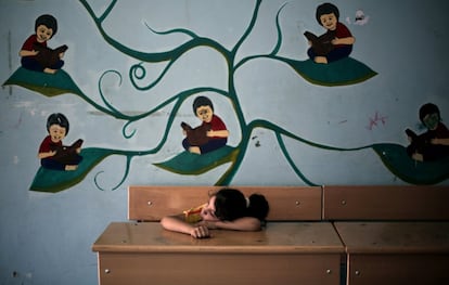 In this Monday, July 14, 2014 photo, young Palestinian girl Fulla Attar, 10, rests in a classroom of the New Gaza Boys United Nations school, where dozens of families have sought refuge after fleeing their home in fear of Israeli airstrikes. 20 U.N. schools took in more than 17,000 displaced Gazans, many of them children, after Saturday's warnings by Israel that civilians must clear out of northern Gaza. (AP Photo/Khalil Hamra)