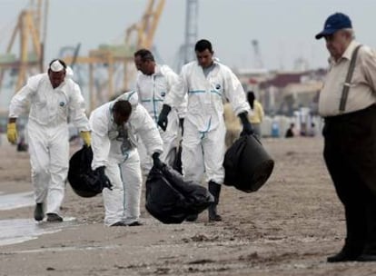 Operarios de limpieza buscaban ayer las escasas manchas de fuel que alcanzaron la playa de la Malva-rosa de Valencia.