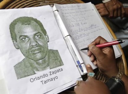 Una mujer firma en el libro de condolencias por Orlando Zapata.