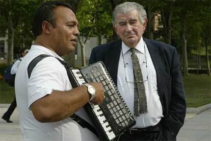 Antonio Gamoneda, ayer en Madrid, junto a un músico callejero.