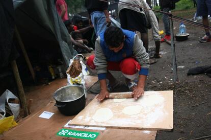 Uno de los migrantes prepara pan 'naan' en el exterior del edificio en Bihac.