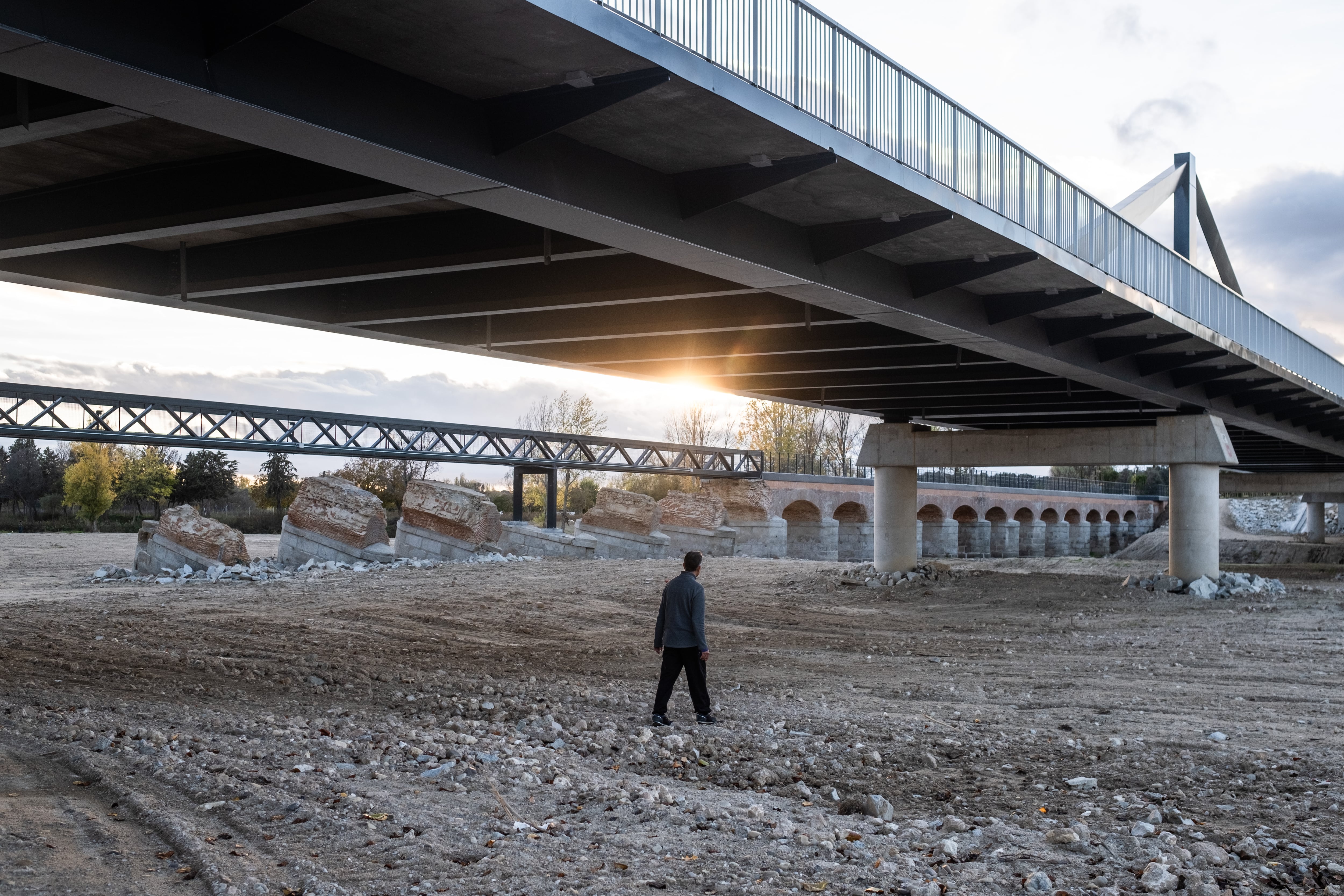 
Una persona cruza por el río seco de Aldea del Fresno donde circuló la dana y cuyo puente quedó arrasado. 
