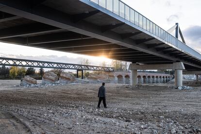 Una persona attraversa il fiume in secca di Aldea del Fresno dove circolava la dana e il cui ponte fu distrutto.