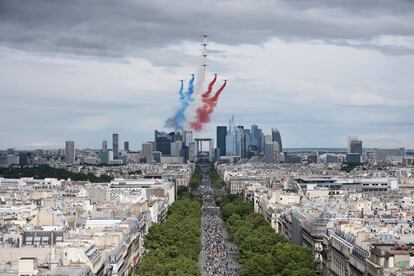 Aviones del equipo de vuelo acrobático francés Patrouille de France (PAF) con humo de los colores de la bandera nacional francesa durante el desfile en los Campos Eliseos.