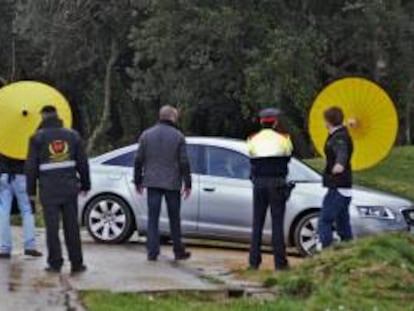 Efectivos de la policía y miembros de seguridad ante el vehículo que traslada al president Artur Mas, al almuerzo que diferentes políticos y empresarios catalanes y del resto del Estado mantienen hoy en la masía propiedad del empresario cazatalentos Luis Conde (Seelinger & Conde), ubicada en la localidad ampurdanesa de Fonteta (Girona).