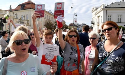 Manifestantes en Varsovia sostienen ejemplares de la Constitución polaca  este martes para protestar contra la reforma de la justicia impuesta por el Gobierno.
 